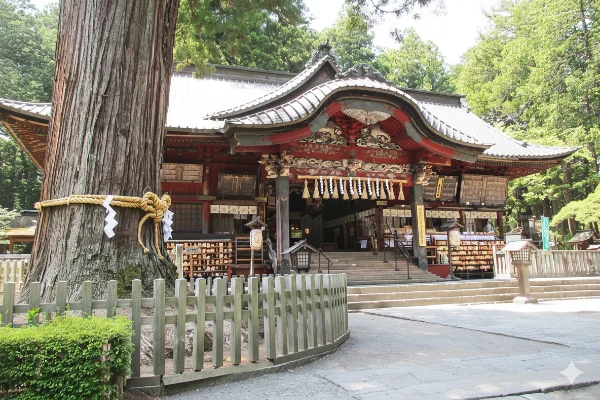 Historic Sengen shrine with traditional torii gate and Mount Fuji in background surrounded by ancient forest